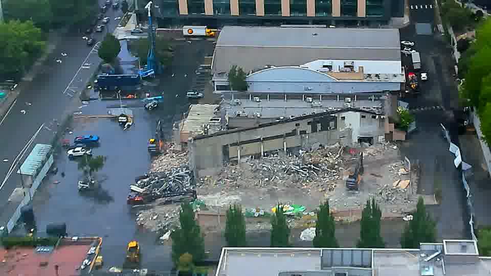 Fixed construction-camera view on June 5, 2026, showing a partially demolished low-rise building, a large rubble field and excavators on the Onni 606 block.