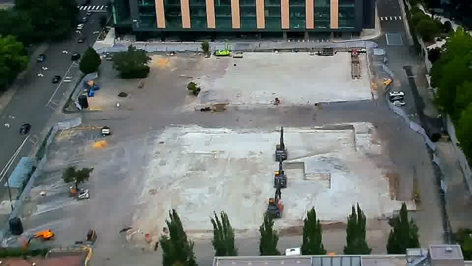 Fixed construction-camera view on June 20, 2026, showing the Onni 606 block cleared of its former above-grade buildings with a broad concrete slab exposed.